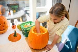 Girl cleaning out Halloween pumpkin photo