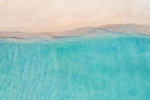 relajante escena de playa aérea, banner de plantilla de vacaciones de vacaciones de verano. las olas surfean con la increíble laguna del océano azul, la orilla del mar, la costa. vista superior perfecta del drone aéreo. playa tranquila y luminosa, junto al mar foto