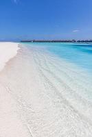 Beautiful panoramic landscape of over water villas, Maldives island, Indian Ocean. Luxury tropical vacation, exotic lagoon, crystal clear water, relaxing blue sky sea. Summer travel tourism paradise photo