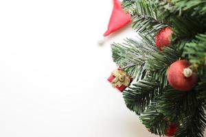 árbol de navidad con adornos de bolas y caja de regalo sobre fondo blanco. enfoque selectivo en la caja foto