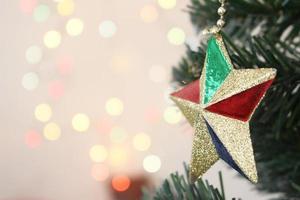 árbol de navidad con adornos estrella dorada con fondo bokeh claro foto