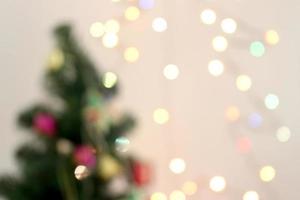 blurred christmas tree with decorations and light bokeh background photo
