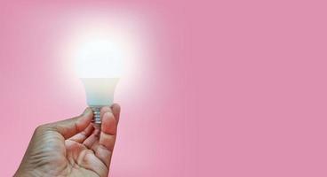 Man holding a light bulb on a pink background, Idea concept photo