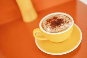 yellow coffee mugs on wooden table in cafe photo