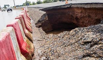 The road was destroyed by water erosion caused by heavy rain and flooding the road. photo