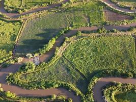 Streams meander in agricultural areas during the rainy season with plenty of water. Green and warm in the morning sunshine. photo