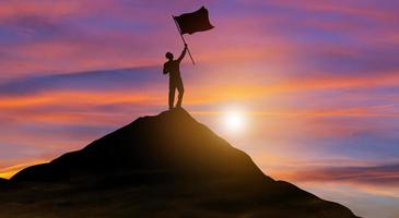 hombre de negocios con bandera en la cima de la montaña. éxito, logro de objetivos, liderazgo y concepto de logro empresarial.