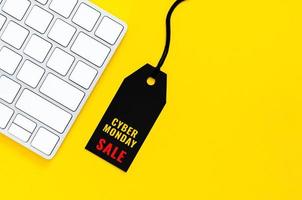 etiqueta de precio negra con teclado inalámbrico para compras en línea sobre fondo amarillo. concepto de lunes cibernético.