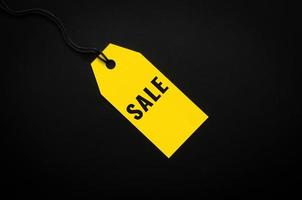 A yellow sale price tag on black background for shopping and discount on Black Friday concept. photo