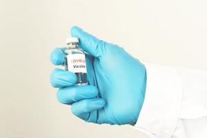 Covid-19 vaccine in the hands of researchers female doctor holding a syringe and a bottle of medicine with vaccine for injecting immunity from covid 19 photo