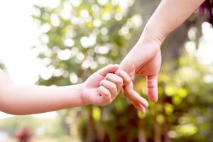 manos de los niños con cuidado, preocupación, calidez de las madres. foto