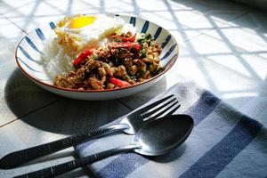 Stir Fried Basil with Minced Pork and Fried Egg is a popular dish because it's quick and easy to make.  spicy taste photo