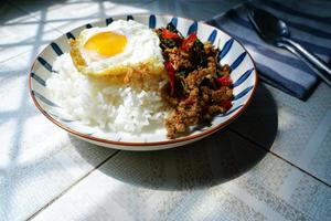 Stir Fried Basil with Minced Pork and Fried Egg is a popular dish because it's quick and easy to make.  spicy taste photo