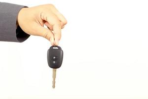 Salesman is carrying the car keys delivered to the customer at the showroom with a low interest offer. Special promotion photo