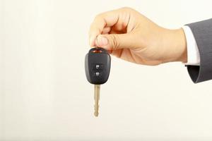 Salesman is carrying the car keys delivered to the customer at the showroom with a low interest offer. Special promotion photo