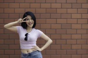 Portrait of hipster girl  on brick wall background,Beautiful asian woman pose for take a photo