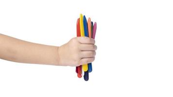 child holding multicolored pencils isolated on white background. copy space template. wax crayons photo