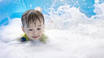 Boy playing with bubbles in the swimming pool at home on summer vacation. happy family holiday concept. child's happy face, swimming boy, child happiness, water and soap bubbles photo