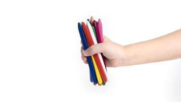 child holding multicolored pencils isolated on white background. copy space template. wax crayons photo