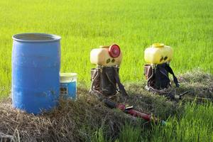 pulverizador atomizador de mochila motorizado en el fondo del campo de arroz del agricultor. agricultura y agroindustria, agroindustria. foto