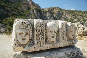 caras de piedra en la antigua ciudad de myra en demre, antalya, turkiye foto