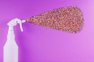 Spray splashes with colored balls on a pink background. photo