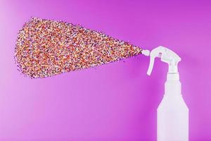Spray splashes with colored balls on a pink background. photo