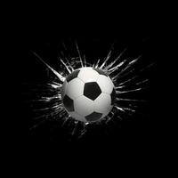 Fast soccer ball through broken glass on black background photo