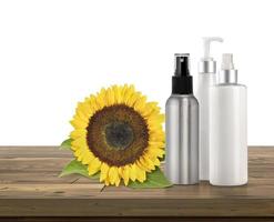 Set of shampoo bottles and sunflowers on a wooden table photo