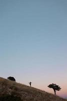 Silhouette of the person on the high rock at sunset photo