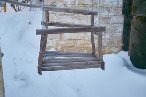 columpio vacío en el patio de recreo - cubierto de nieve foto