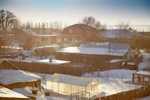 Russian village in winter, not cleared of snow road. photo