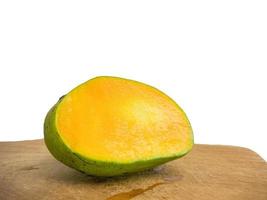 the mango is split on the wood. so that the inside is visible in orange .isolated on a white background photo