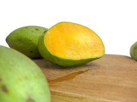 the mango is split on the wood. so that the inside is visible in orange .isolated on a white background photo