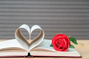 páginas de libro con forma de corazón curvo y rosa roja foto