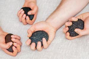 Massager's hands holding massage stones. photo