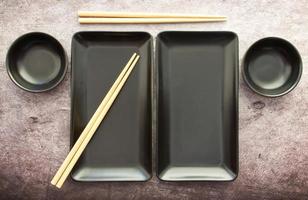 Black Slate Plate with Chopstick grey concrete background. Flat Lay. Asian Food Concept photo