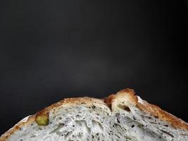 Close up Side view, part of baked brown sourdough natural yeast, artisan, dark background with copy space above photo