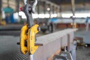 Selective focus of Steel clamp lifting for fabrication work in factory lifting H-Beam with overhead crane photo