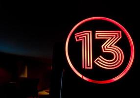 número de la suerte 13 en el letrero de luz roja en la parte superior de la puerta del cine foto