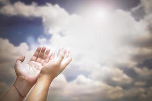 Soft focus of hands of human are pray and worship on blue sky background with sunlight, Soul of prayer man, Spirituality with believe and religion photo