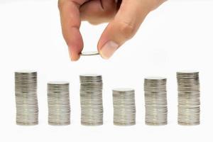 Man hand holding coin with coins stack arranged as graph on white background, Money growing concept and sustainable investment, Business success and financial concept, Banking and economy idea photo