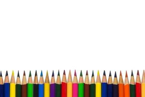 muchos lápices multicolores alineados en una fila aislados en fondo blanco con espacio de copia, arte y educación foto