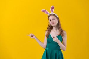 Young woman with bunny ears for easter holidays presenting an idea smiling photo