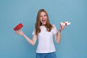 Excited young woman in white t-shirt isolated on blue background. photo