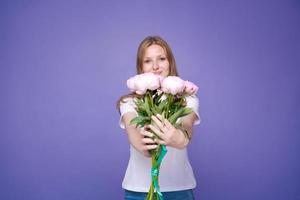 Portrait cheerful young lady with romantic spring bouquet pink peonies photo