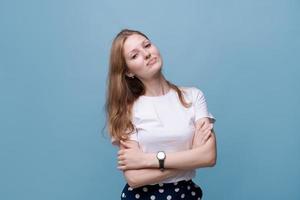 Smiling beautiful millennial girl in white t-shirt stand with arms crossed photo