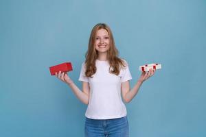 Excited young woman in white t-shirt isolated on blue background. photo