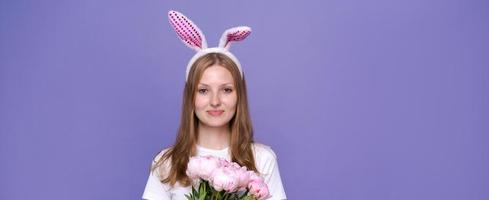 Charming happy cute girl with pink easter bunny ears and bouquet spring photo