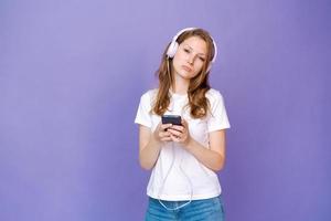 Young woman watching video clips on the phone in wired headphones in casual photo